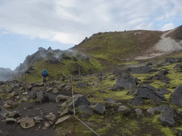 Hiker kék hátizsák a Laugavegur Trek színes Rhyolit Rainbow Mountain tarka vulkúk és geotermikus Fumarole. Landmannalaugar at Fjallabak Nature Reserve, Highlands Izland — Stock Fotó