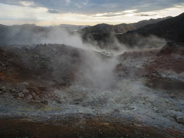 Geothermal fumarole and colorful Rhyolit mountain with multicolored volcanos. Sunrise in Landmannalaugar at Fjallabak Nature Reserve, Highlands Iceland — Stock Fotó