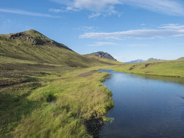 Hermosas colinas verdes, hierba exuberante y río azul junto al camping en el lago Alftavatn. Día soleado de verano, paisaje de la Reserva Natural de Fjallabak en las Highlands Islandia parte del senderismo Laugavegur —  Fotos de Stock