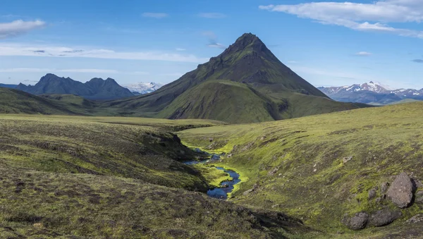 在冰岛菲亚拉巴克自然保护区的劳加韦古尔徒步之旅中，恩斯特鲁尔和阿尔夫塔瓦坦露营地之间，绿油油山的全景火山景观，有郁郁葱葱的青苔和蓝色的小溪水 — 图库照片