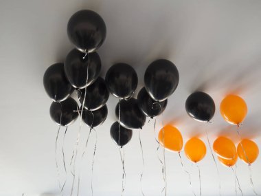 beyaz tavan arka plan üzerinde cadılar bayramı veya doğum günü için turuncu ve siyah hava balonları demet. Tatiller, dekorasyon ve parti konsepti
