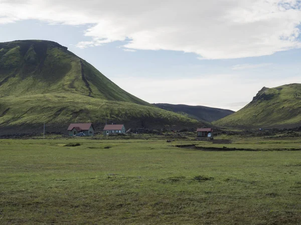 Hvanngil campingplatz weg in lavafeld und grünen tal, kleine häuser hvanngil hütte. vulkanische berge vulkanische landschaft mit blauem himmel, laugavegur weg zwischen emstrur-botnar und alftavatn, zentral — Stockfoto