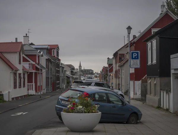 Islande, Reykjavik, 30 juillet 2019 : rue du centre de Reykjavik avec vieilles maisons historiques en tôle rouge, église et voitures garées . — Photo