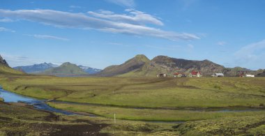 İzlanda Dağlık Fjallabak Doğa Rezerv güzel manzara nehir, yeşil tepeler ve buzul ile mavi Alftavatn göl üzerinde kamp yerinde dağ kulübeleri ile Panoramik manzara