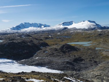 Buzul Smorstabbreen üzerindeki Krossbu 'dan panoramik manzara, Jotunheimen Ulusal Parkı, Batı Norveç' teki karlı dağlar ve mavi göller