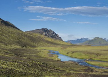 Güzel yeşil tepeler, yemyeşil çimenler ve Alftavatn gölündeki kamp alanının yanında yaya köprüsü olan mavi nehir. Yaz güneşli bir gün, İzlanda 'nın Highlands bölgesindeki Fjallabak Doğa Koruma Alanı' nın manzarası