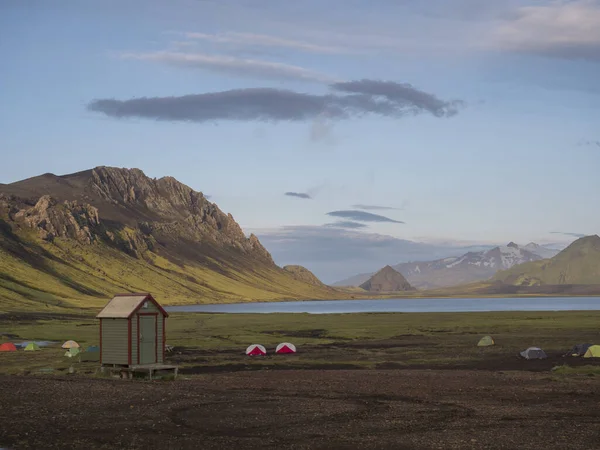 Coloridas tiendas de campaña en el camping en el lago azul Alftavatn con colinas verdes y glaciares en el otro mundo hermoso paisaje de la Reserva Natural Fjallabak en las Tierras Altas de Islandia parte de la famosa —  Fotos de Stock