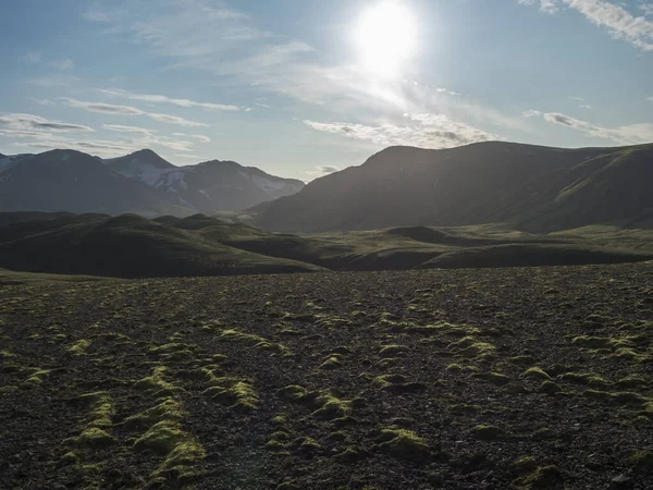 Paisaje volcánico con montañas cubiertas de nieve, colinas verdes y tierra de grava de lava cubierta de musgo exuberante. Reserva Natural de Fjallabak en las Tierras Altas de Islandia — Foto de Stock