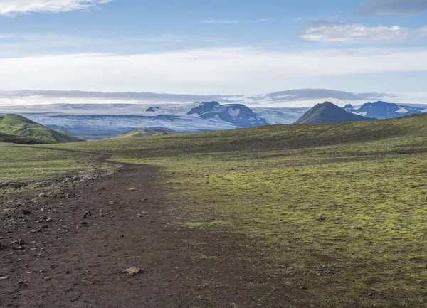 Islandská krajina s pěšinkou Laugavegur turistické stezky s výhledem na Tindfjallajokull ledovec, zelené kopce a láva štěrková zem pokrytá trávou a mechem. Přírodní rezervace Fjallabak, Island — Stock fotografie