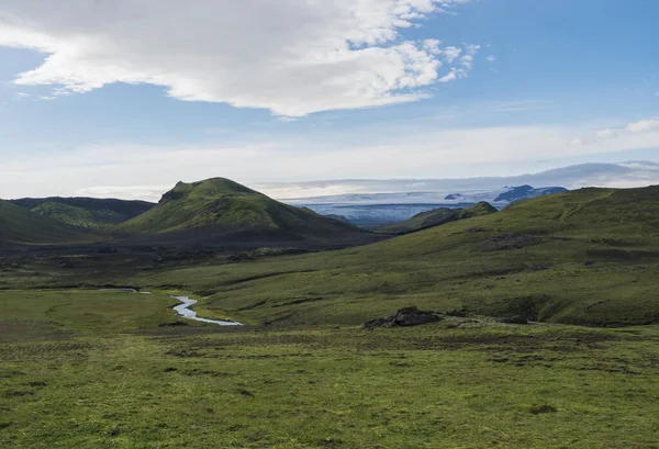 Islandská krajina s ledovcem Tindfjallajokull, zelenými kopci, říčním potokem a bujnou trávou a mechem. Laugavegur turistické stezky, Fjallabak přírodní rezervace, Island. Letní modré nebe — Stock fotografie