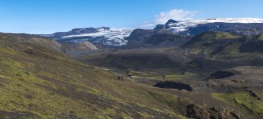 Mavi Markarfljot nehir kanyonu, yeşil tepeler ve göz jafjallajokull volkanik buzulu ile panoramik manzara. Laugavegur yürüyüş yolu. Fjallabak Doğa Koruma Alanı, İzlanda. Yaz masmavi gökyüzü