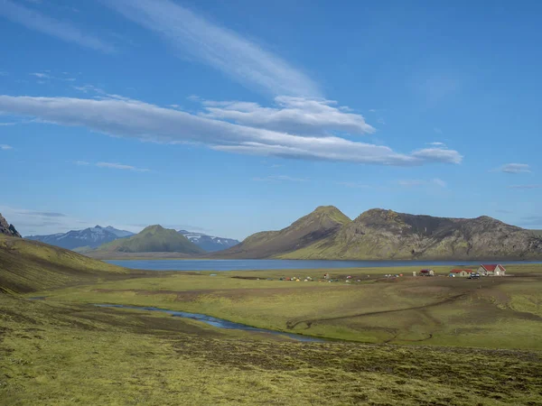 Coloridas tiendas de campaña en el camping en el lago azul Alftavatn con colinas verdes y glaciares en el otro mundo hermoso paisaje de la Reserva Natural Fjallabak en las Tierras Altas de Islandia parte de la famosa — Foto de Stock