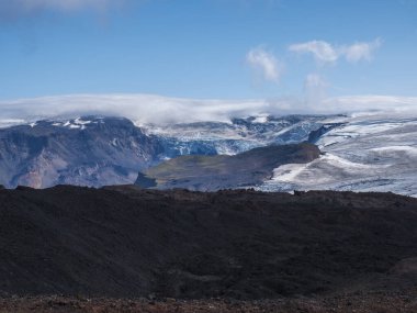 Eyjafjallajokull buzulu ve volkan, lav oluşumları, kar, buz ve yeşil yosunlar ile Godland ve Thorsmork manzarasına bakın. İzlanda, Fimmvorduhals yürüyüş parkuru. Yaz bulutlu günü.