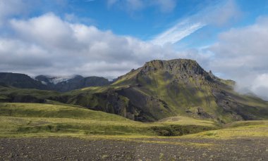 Godland manzarası panoramik nefes kesen manzara ve engebeli yeşil yosun kaplı tepe ve Eyjafjallajokull buzulu, İzlanda, Fimmvorduhals yürüyüş yolu. Yaz bulutlu günü.