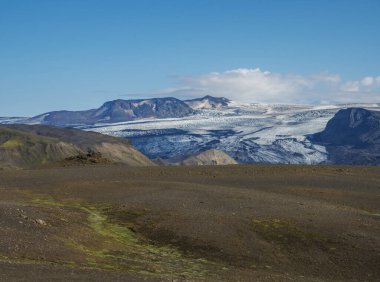 Göz jafjallajokull buzulu dili, Markarfljot nehri ve yeşil tepeli İzlanda manzarası. Fjallabak Doğa Koruma Alanı, İzlanda. Yaz masmavi gökyüzü