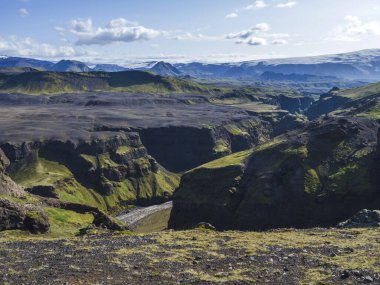 Görkemli Markarfljotsgljufur Kanyon geçidine, nehre ve Tindfjallajokull buzulunun diline ve yeşil tepelere bakın. Fjallabak Doğa Koruma Alanı, İzlanda. Yaz masmavi gökyüzü, bulutlar.