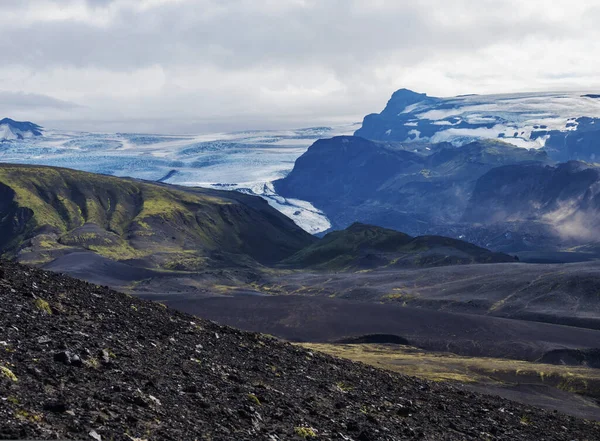 Islandzki krajobraz pustyni lawy z językiem lodowca Tindfjallajokull i zielonymi wzgórzami. Rezerwat przyrody Fjallabak, Islandia. Lato błękitne niebo, chmury. — Zdjęcie stockowe