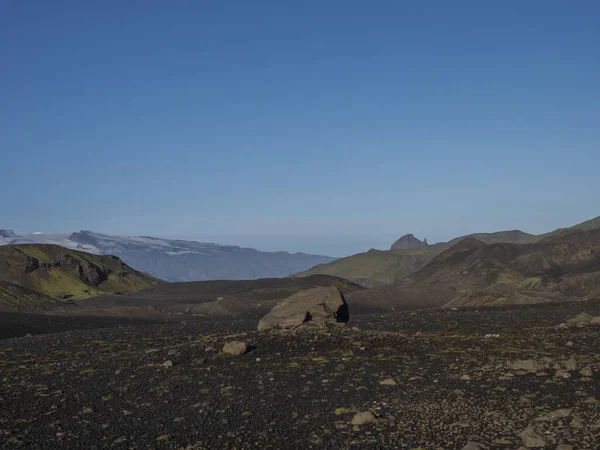 Paisaje del desierto de lava islandesa en la ruta de senderismo Laugavegur con gran roca de piedra y vista de la montaña unicornio Einhyrningur. Reserva Natural de Fjallabak, Islandia. Cielo azul de verano — Foto de Stock