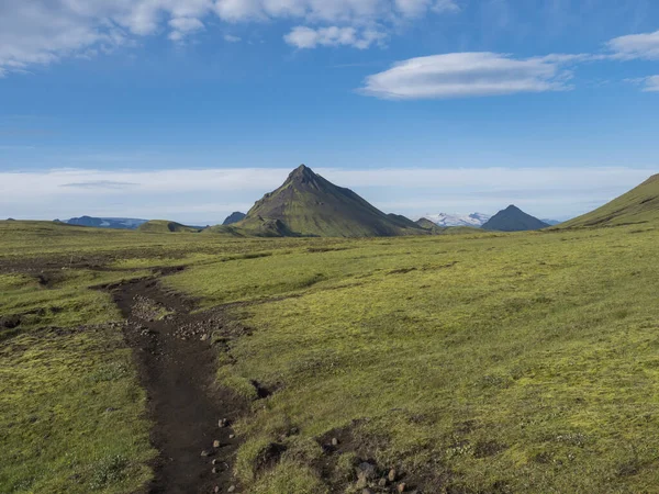 Ηφαίστειο τοπίο με μονοπάτι από Laugavegur trek και πράσινο Storasula βουνό με πλούσια βρύα και χαμηλά σύννεφα. Fjallabak Nature Reserve, Ισλανδία. Μπλε φόντο του ουρανού, αντίγραφο χώρου. — Φωτογραφία Αρχείου