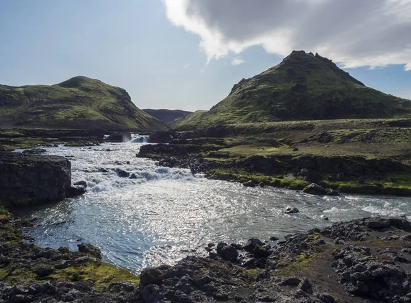 Paisaje volcánico islandés con cascada del río Innri-Emstrura, verdes colinas y montañas en la ruta de senderismo de Laugavegur. Reserva Natural de Fjallabak, Islandia. Cielo azul de verano —  Fotos de Stock