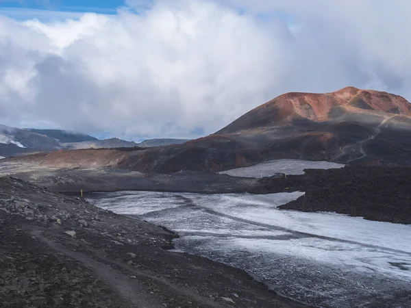 Красный и черный вулканический ландшафт Исландии на Fimmvorduhals пешеходная тропа с ледником вулкан лава поле, снег и магни и Муди холм, созданный извержением Eyjafjallajokull в 2010 году, который повлиял на Ай — стоковое фото