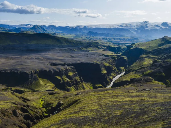 Vista sobre la majestuosa garganta del cañón de Markarfljotsgljufur, el río y la lengua glaciar Tindfjallajokull y las verdes colinas. Reserva Natural de Fjallabak, Islandia. Cielo azul de verano, nubes . — Foto de Stock