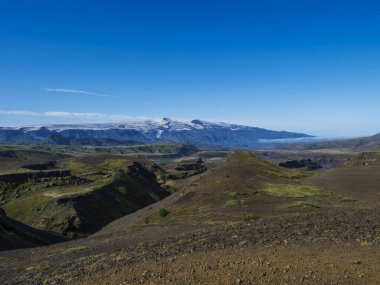 Icelandic landscape with blue Markarfljot river canyon, green hills and eyjafjallajokull volcano glacier. Laugavegur hiking trail. Fjallabak Nature Reserve, Iceland. Summer blue sky