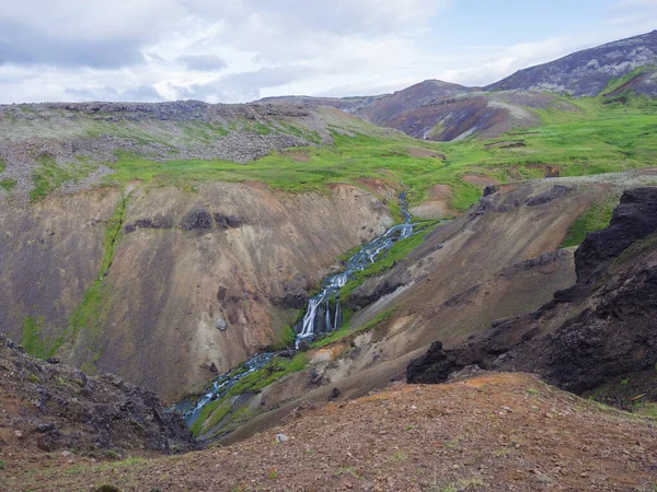 Vallée de Reykjadalur avec des sources chaudes rivière, prairie luxuriante d'herbe verte, rochers et collines avec de la vapeur géothermique. Islande méridionale près de Hveragerdi. Matin ensoleillé d'été, ciel bleu . — Photo