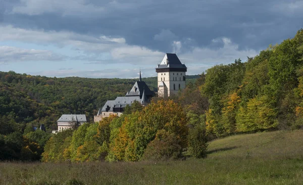 Karlstejn gotische Staatsburg in der Nähe von Prag, die berühmteste Burg in der Tschechischen Republik mit Graswiesen und Herbst farbigen Bäumen und Wäldern. blauer Himmel Wolken Hintergrund. in der Nähe von Prag. — Stockfoto