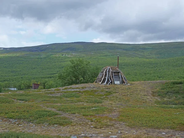 Abadoned Sami chata Goathi w zielonych wzgórzach krajobraz Abisko Parku Narodowego. Goahti jest Lappish tradycyjne mieszkanie wykonane z tkaniny, mchu torfowego i drewna. Laponia, północna Szwecja na szlaku Kungsleden. — Zdjęcie stockowe