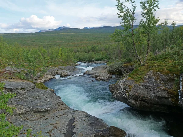 Paisagem com corredeiras de rio glaciar azul selvagem Kamajakka, rocha, bétula, montanhas verdes na aldeia de Rovvidievva sami, Lapônia, Norte da Suécia, Verão dia ensolarado — Fotografia de Stock