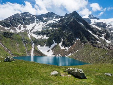 Güzel turkuaz mavi dağ gölü Grunausee yeşil çayır ve karla kaplı dağ tepeleri ile dağlık arazide. Tyrol, Stubai Alpleri, Avusturya, yaz güneşli gün