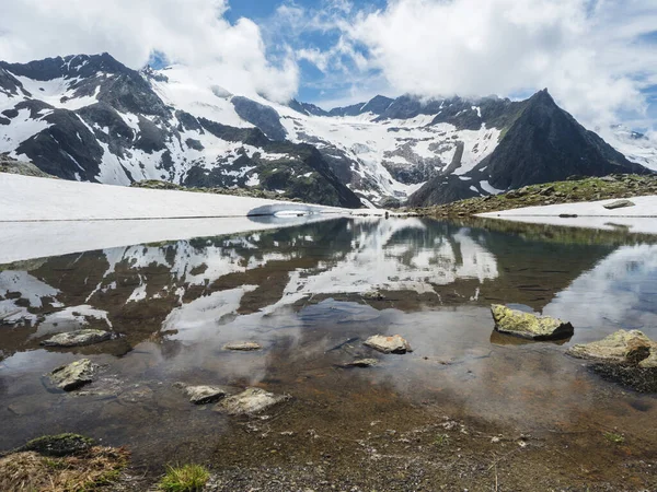 Nádherné ledovcové jezero s prameny z tavícího ledovce s ostrými zasněženými vrcholky hor odrážejícími se na vodní hladině. Tyrolsko, Stubajské Alpy, Rakousko, letní slunečný den — Stock fotografie