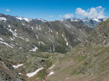 Stubai yürüyüş parkurunda dolambaçlı bahar akıntısı ve karla kaplı tepeleri olan dağ vadisi manzarası, Stubai Hohenweg, Tyrol, Stubai Alpleri, Avusturya