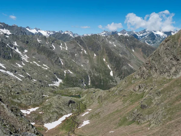 Pohled na horské údolí s klikatým pramenem a zasněženými štíty na Stubajské turistické stezce, Stubai Hohenweg, Letní skalnatá krajina Tyrolska, Stubajské Alpy, Rakousko — Stock fotografie