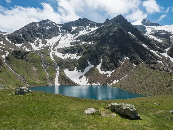Hermoso azul turquesa lago de montaña Grunausee en el paisaje alpino con prado verde y picos de montaña nevados. Tirol, Alpes Stubai, Austria, día soleado de verano — Foto de Stock