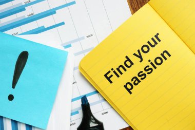 Tutkunuzu bulun'u gösteren metin işareti. Metin sarı not defterine yazılmış. Kavramsal fotoğraf grafikler ve renkli kağıtlar, işaretleri, ahşap arka plan ile kağıtları gösterir.