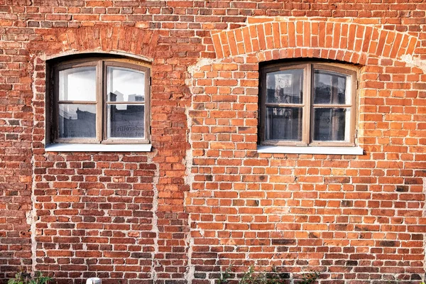 Old red brick wall with windows.