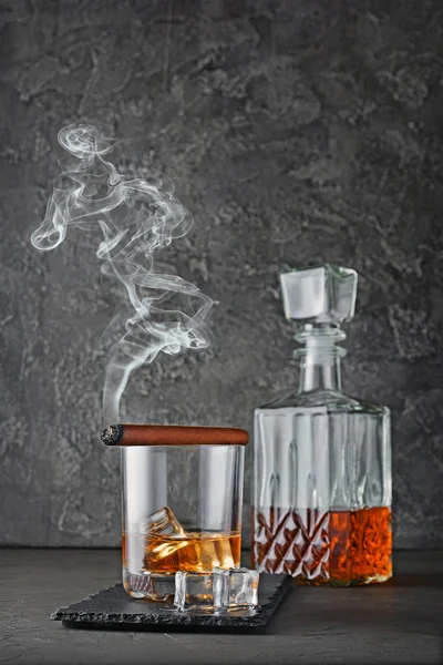 Güçlü alkollü içki scotch viski buzlu eski moda cam ve gri beton zemin üzerine yasaktır puro ile sürahi