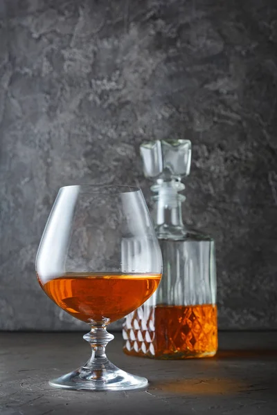 Algılayıcı cam ve kristal sürahi gri beton adam üzerinde güçlü alkollü içki konyak