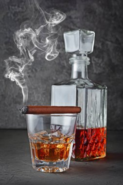 Güçlü alkollü içki scotch viski buzlu eski moda cam ve gri beton zemin üzerine yasaktır puro ile sürahi