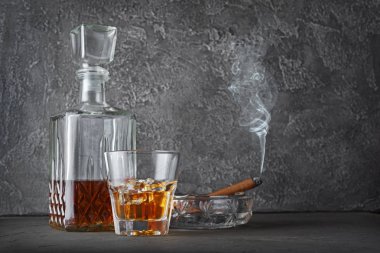 Güçlü alkollü içki scotch viski küllük gri beton zemin üzerine yasaktır puro ile eski moda cam ve sürahi buzlu