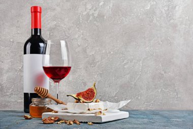Taze incir, fındık, bal ve ahşap kesme tahtası ve gri beton zemin kırmızı şarap ile gurme meze beyaz brie peyniri veya camembert