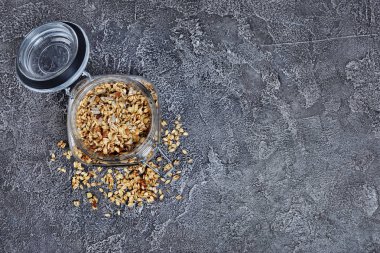Kopya alanı gri beton zemin üzerine ile sağlıklı kahvaltı ev yapımı granola ile fındık ve ayçiçeği tohumu açık cam üzerinde üstten görünüm