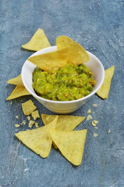 Meksika Nacho çiplerle yeşil guacamole sos ya da dip beton zemin üzerine beyaz kase