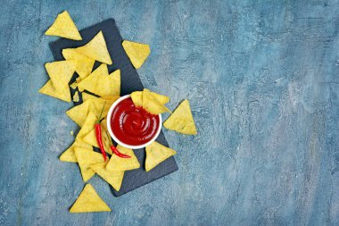 Beyaz kase ve siyah arduvaz tahta üzerinde sıcak biber biber soslu baharatlı kırmızı Meksika cips cips ve beton arka plan kopya alanı ile üstten görünüm