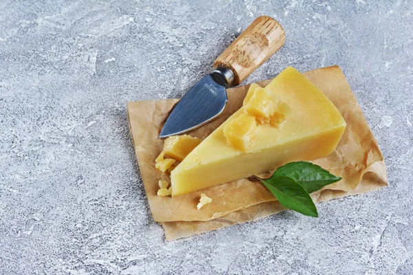 Queso Parmesano Sobre Papel Pergamino Con Hojas Albahaca Cuchillo Sobre —  Fotos de Stock