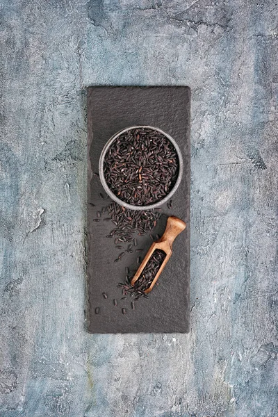 Bowl Uncooked Black Rice Wooden Scoop Slate Board Blue Concrete — Stock Photo, Image