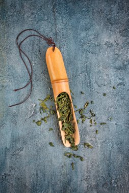 Mavi beton zemin üzerine yeşil çayın bambu kepçe içinde üstten görünüm