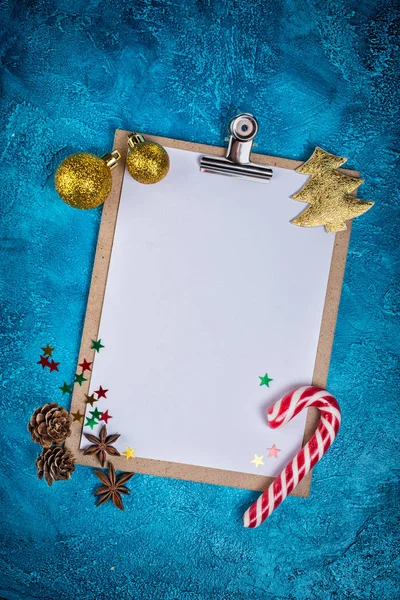 青の具体的背景に紙とおもちゃやお菓子として クリスマスの装飾の空白の白いシートを使用モックアップ組成の平面図 — ストック写真